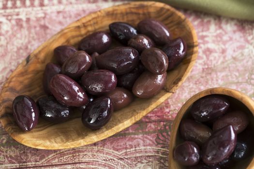 Wooden bowl and scoop of kalamata olives