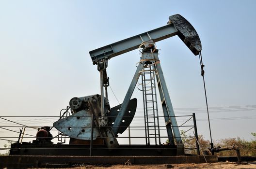 old pumpjack pumping crude oil from oil well