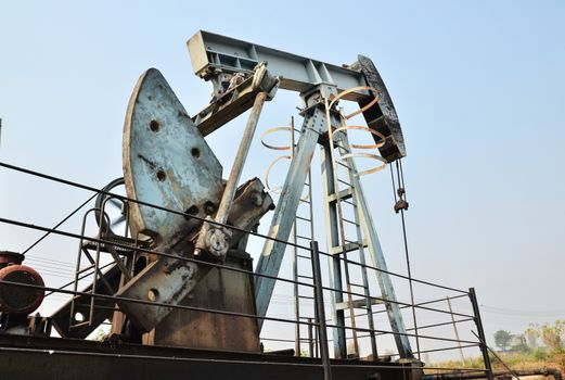 old pumpjack pumping crude oil from oil well
