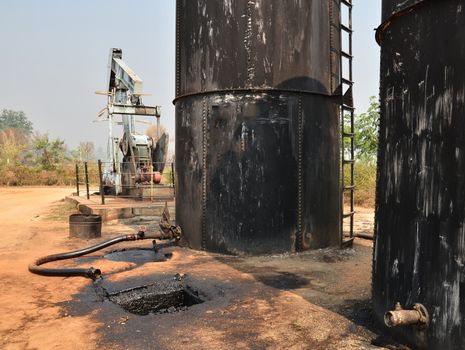 old pumpjack pumping crude oil from oil well