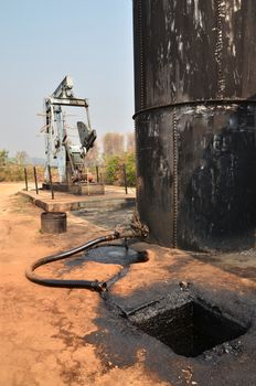 old pumpjack pumping crude oil from oil well