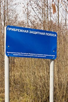 Banner reading "Coastal protection zone" in the woods. Russia