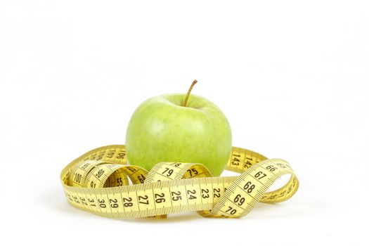 Green apple and yellow measuring tape isolated on white background