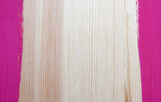 Two stripes of paint form vertical borders on pine board