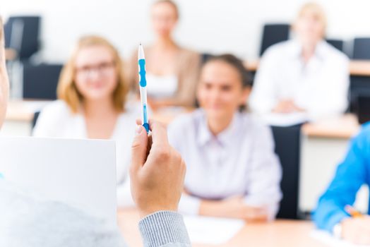 close-up of hands of a teacher with a ballpoint pen, the teacher focuses attention on himself gesture