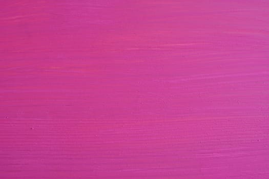 Wooden board painted pink, wood grain texture shows through