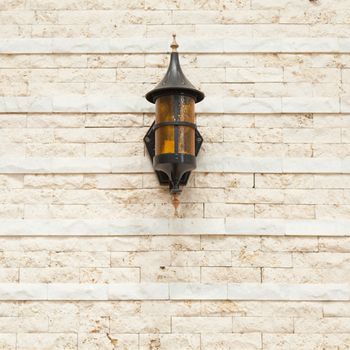 Lamp on the wall Black lantern on the wall made ������of small bricks.