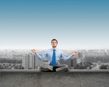 image of a businessman meditating on a concrete parapet