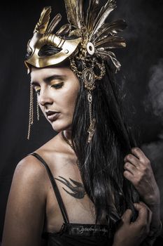 Sensual young woman with golden mask jewelry