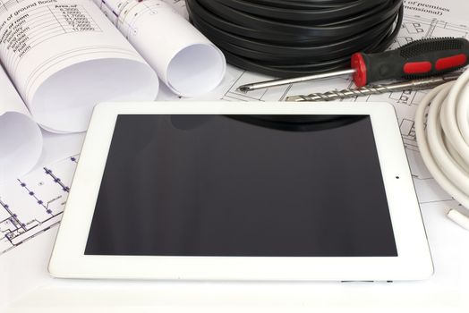 Electrical cable and tablet pc on the construction drawings. Repair and construction of electric systems