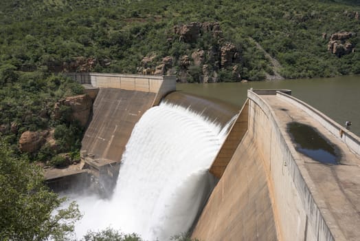 the swadini dam waterfall near the blyde river with the dragensberg as background