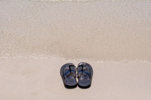 Beach sandals on a sandy beach with background