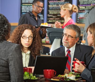 Serious adult business people meeting at indoor cafe