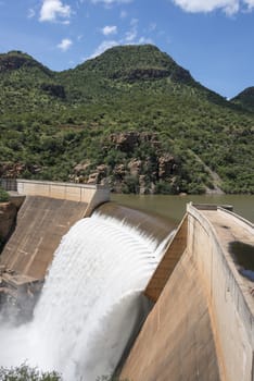 the swadini dam waterfall near the blyde river with the dragensberg as background