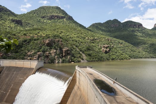 the swadini dam waterfall near the blyde river with the dragensberg as background