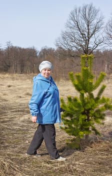 Elderly beautiful woman in a spring forest walks one
