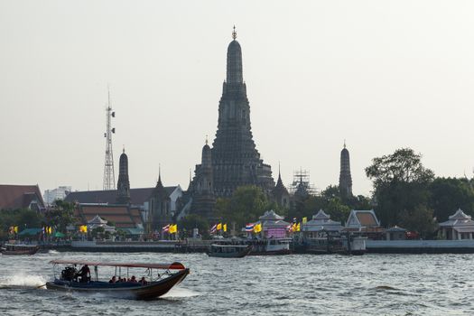 Long tail boat cruising in the river For tourists visiting Thailand. In the background is Wat Arun