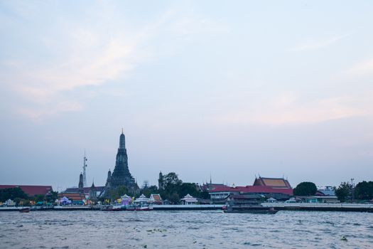 Long tail boat cruising in the river For tourists visiting Thailand. In the background is Wat Arun