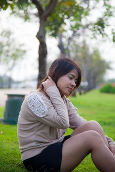 Portrait Asian woman sitting in the park. Sitting on fresh grass.