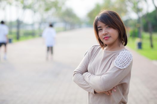 portrait asian woman standing in park.relax and smile woman in park.