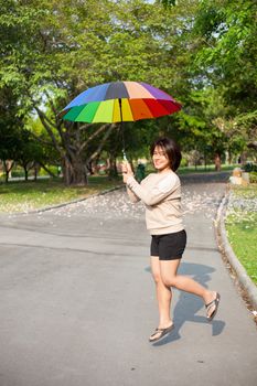 Women holding umbrella On the path in the park.