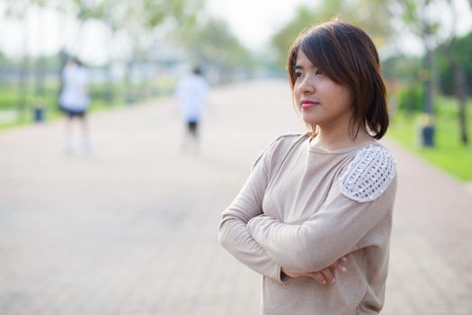 Portrait Asian woman standing in a park and looking forward to the destination.