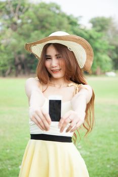Asian woman smiling and handing a mobile phone.Smiling happy and Relax.