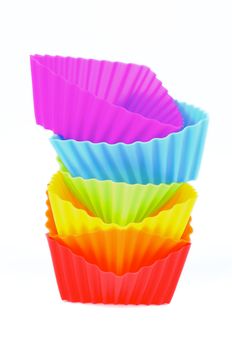 Pile of Silicone Rainbow Colored Cupcake Molds In a Row isolated on white background