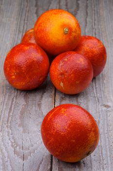 Heap of Ripe Full Body Blood Oranges isolated on Rustic Wooden background