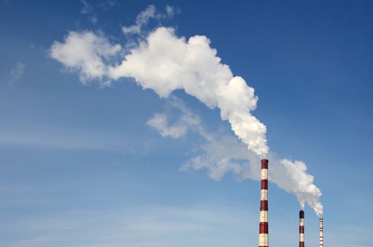 industrial smoke from chimney on blue sky