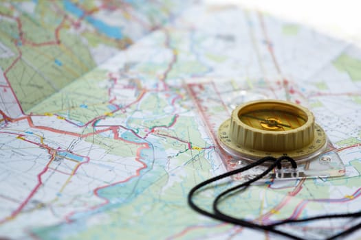 old touristic handheld compass on detailed territory map 