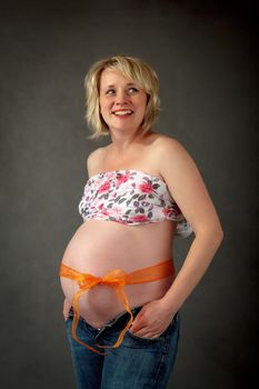 beautiful smiling pregnant woman tenderly holding her tummy