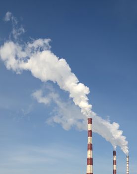 industrial smoke from chimney on blue sky