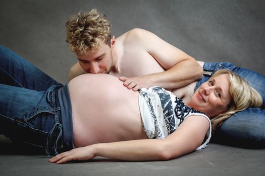 Loving happy couple, pregnant woman in love with her husband, romantic kissing scene