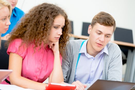 students together to discuss the lecture, come together, looking at laptop monitor