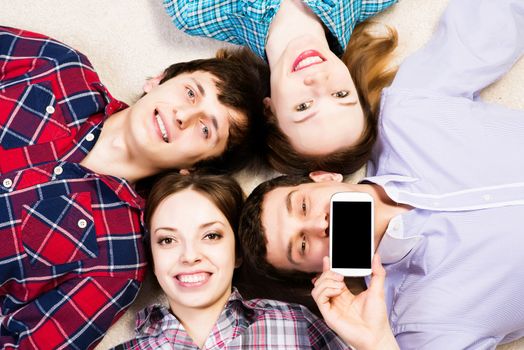 four young people are together, the young man pressed his lips to the phone