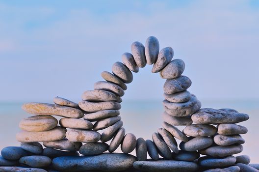 Arch of stones between of the pebbles on the coast