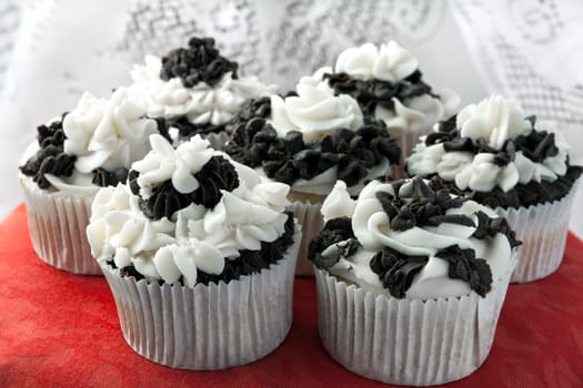 Close up of some decadent gourmet cupcakes with chocolate and vanilla frosting. Shallow depth of field.