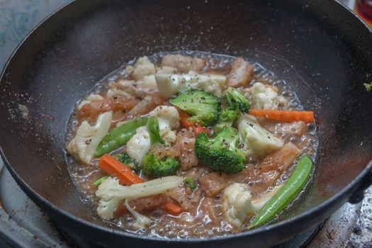 Stir-fried mixed vegetables in a pan of boiling.