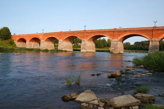 Old Red brick bridge over river Venta in Kuldiga , Latvia