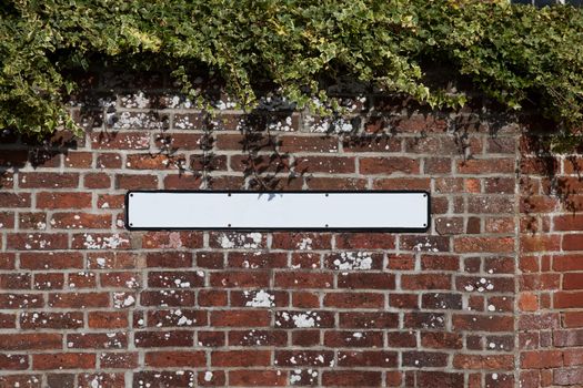 Blank road sign on a brick wall