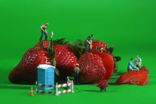 Miniature Construction Workers in Conceptual Food Imagery With Strawberries