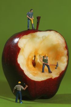 Miniature Construction Workers in Conceptual Imagery With an Apple