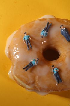 Miniature Police Officers in Conceptual Food Imagery With Doughnuts