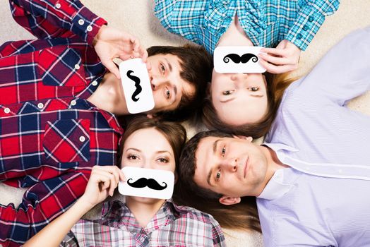 four young men lie together, applied to the face plate with a mustache