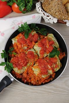stuffed savoy cabbage in a pan under the onion and carrot gravy