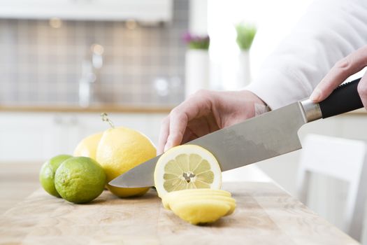 Close up of human cutting lemon and lime