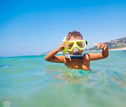 Summer vacation - Portrait of happy boy in face masks and snorkels, sea in background.