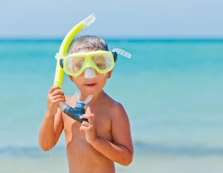 Summer vacation - Portrait of happy boy in face masks and snorkels, sea in background.