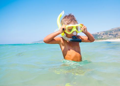 Summer vacation - Portrait of happy boy in face masks and snorkels, sea in background.